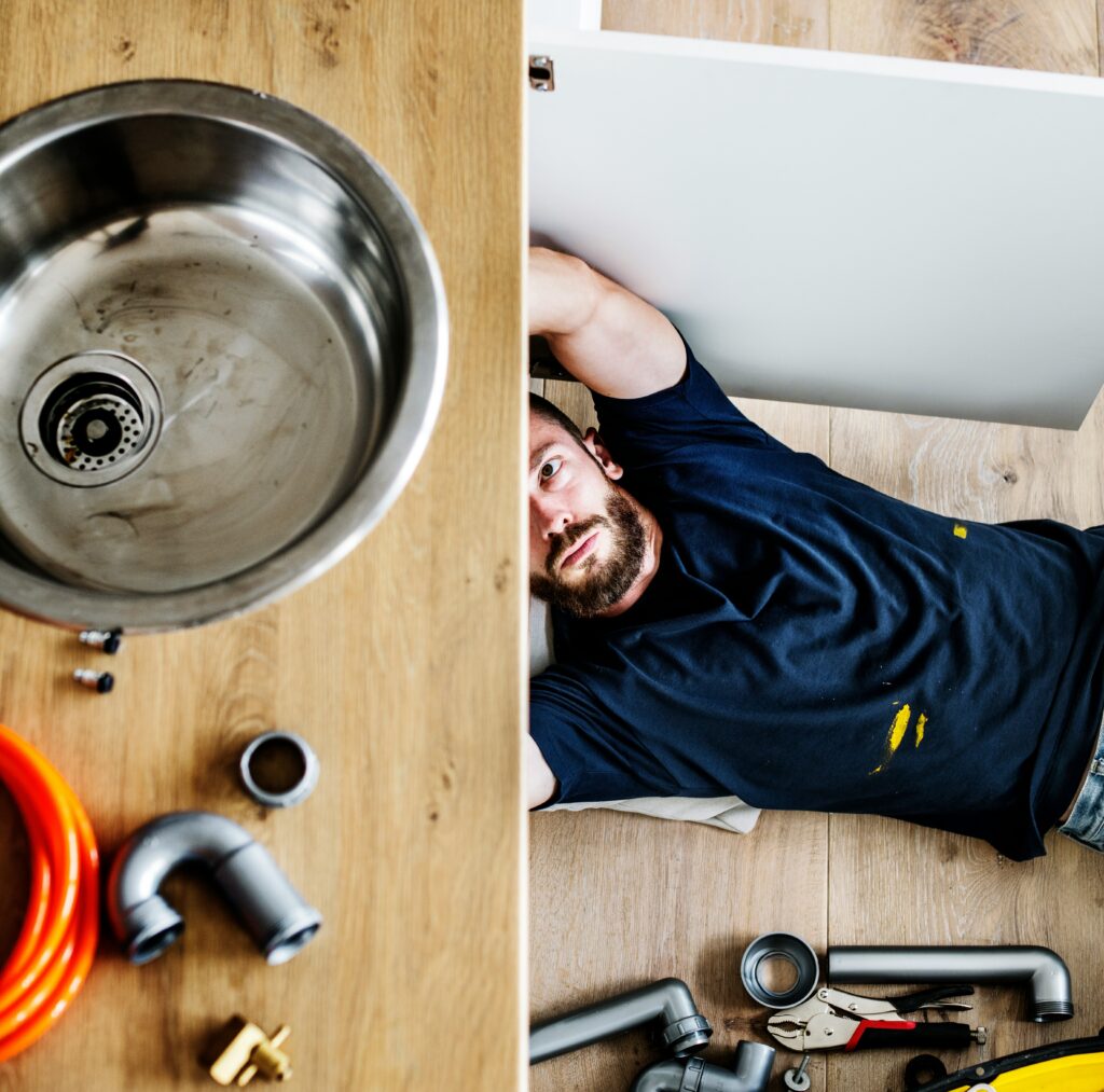 plumber inspecting kitchen plumbing